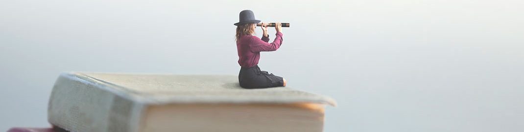 Person sitting on book stack