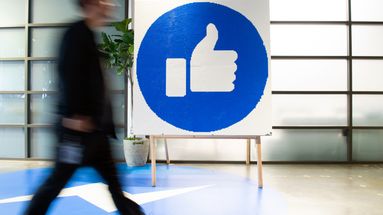 Un employé de Facebook passe devant le "Like" du réseau social, au siège de l'entreprise, à Menlo Park (Californie)