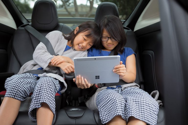 Two girls use Surface Go Lifestyle 1 in a car