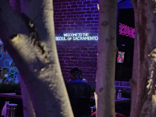 Photo of Pocha House - Sacramento, CA, US. people sitting at tables in front of a brick wall