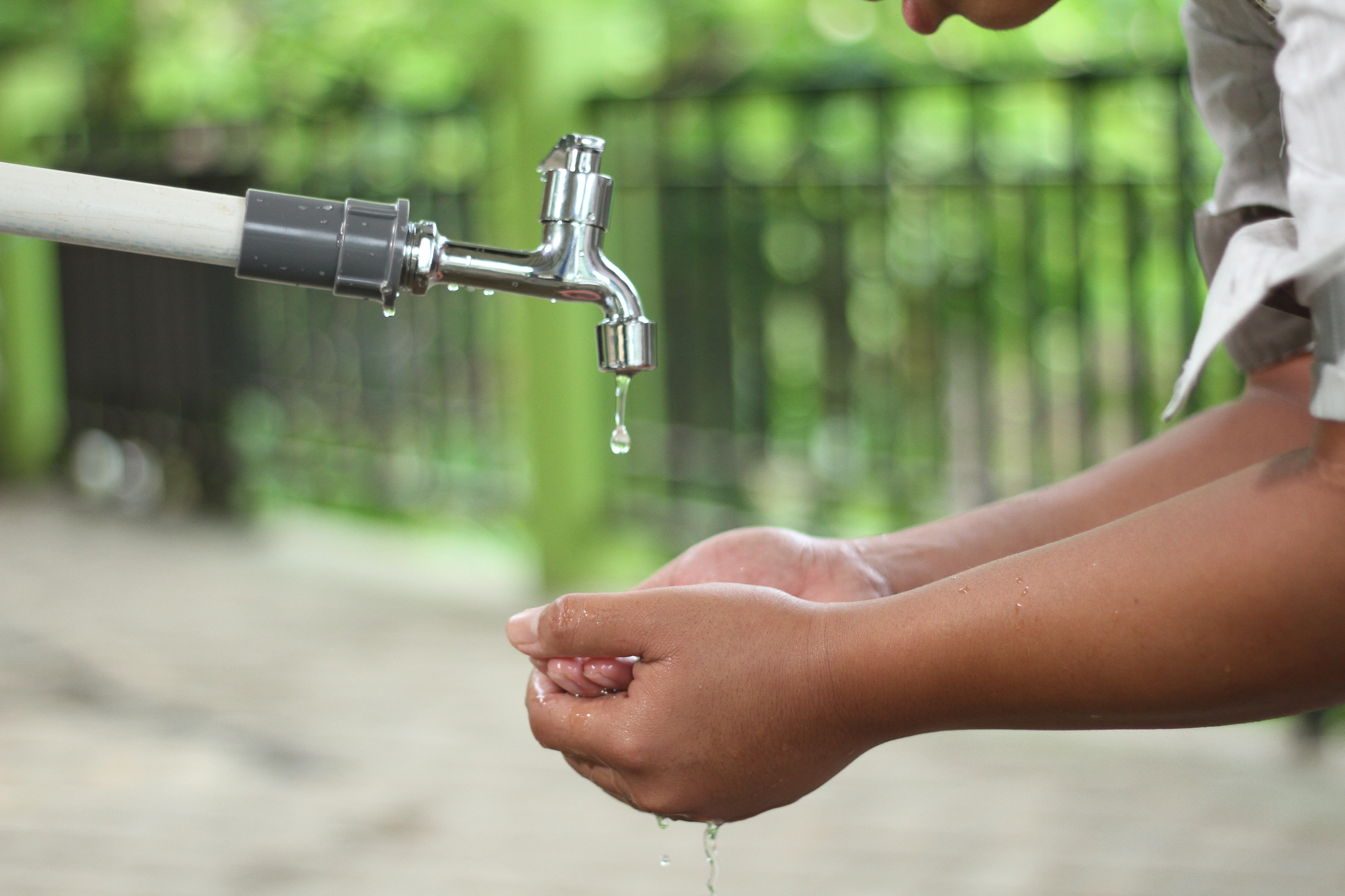 Child washing hands under tap 