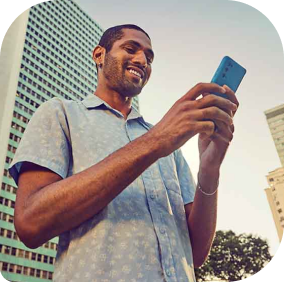 Homem sorrindo enquanto digita em celular