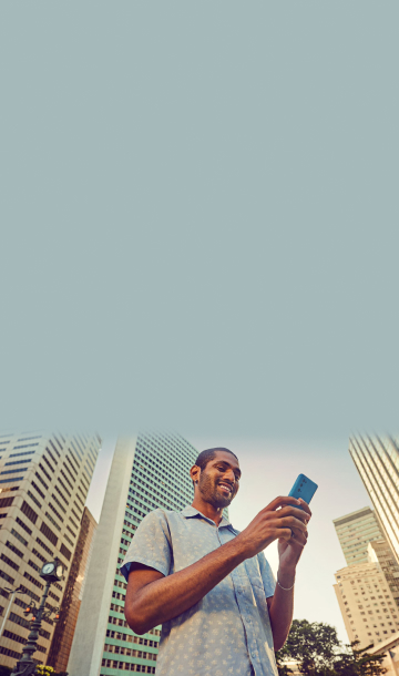 Homem sorrindo enquanto digita em celular