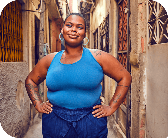 Mulher toda vestida de azul sorrindo com as mãos na cintura