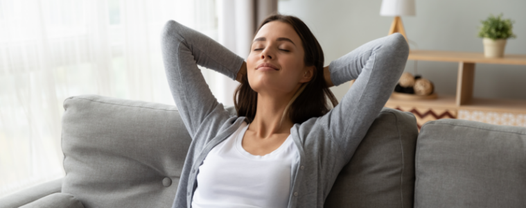 A woman relaxes on her sofa after working out.