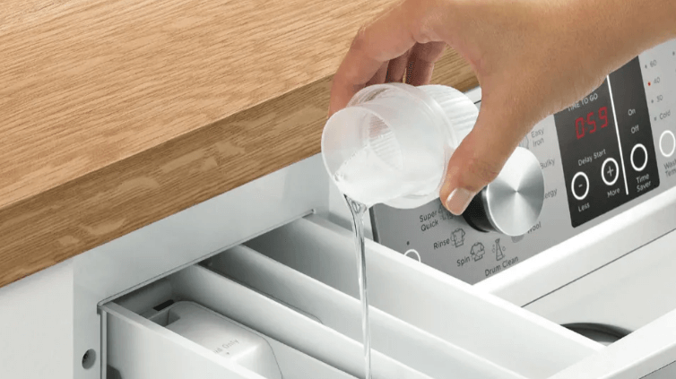 Woman pouring detergent into F&P auto-dosing machine.