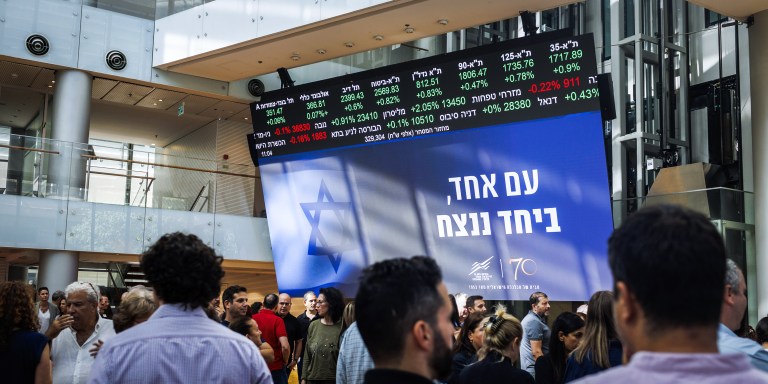 Workers participate in a memorial ceremony to mark a month since the Oct. 7 attack by Hamas militants, inside the Tel Aviv Stock Exchange in Tel Aviv, Israel, on Tuesday, Nov. 7, 2023. Israel's shekel has recouped the bulk of its losses since the war between Israel and Hamas began a month ago, with the central bank's support helping to tame volatility and discourage bets against it. Photographer: Kobi Wolf/Bloomberg via Getty Images