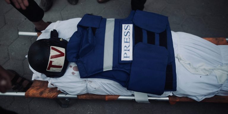 A view of press equipment, belonged to Al-Aqsa TV cameraman Mohammed al-Tanani, on his body during funeral ceremony after al-Tanani lost his life during Israeli attack on the Jabalia Refugee Camp, as the body is brought to al-Aqsa Baptist Hospital in Gaza City, Gaza on October 9, 2024. (Photo by Abood Abusalama / Middle East Images / Middle East Images via AFP) (Photo by ABOOD ABUSALAMA/Middle East Images/AFP via Getty Images)