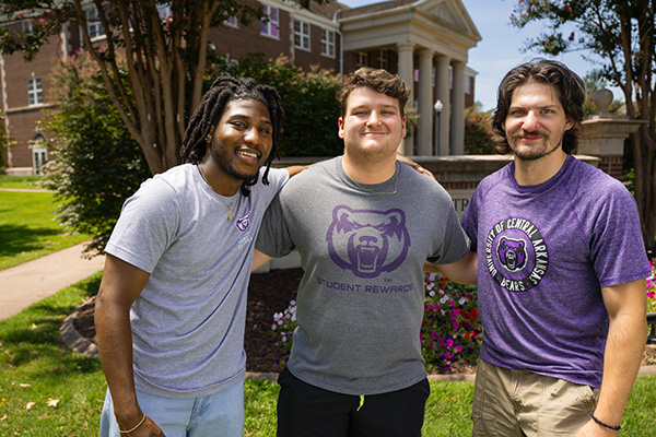 Students standing in front of sign on campus