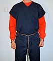 Prisoner shackled with "full harness" transport restraints, consisting of handcuffs on a belly chain, leg irons and a connector chain.