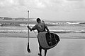 File:Homem segurando prancha de surfe em pé na praia.jpg