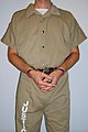 Inmate in handcuffs with a handcuff cover, secured with a belly chain around the inmate's waist.