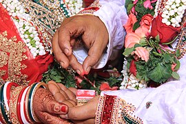 Bridegroom placing Sindoor on bride’s forehead, as part of a Hindu wedding in India