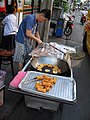 English: Street vendor in Thailand preparing You tiao
