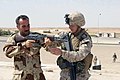 A Marine teaches an Iraqi soldier how to shoot