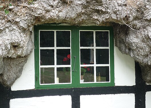 Window at a seaweed covered house on Laesoe island, Denmark