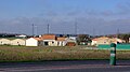 Habitations, ligne électrique et éoliennes en bordure de la D911, à l'entrée de Ruffec, Charente, France.