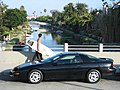 Surfer overlooks Venice Canals as he walks towards Venice Beach