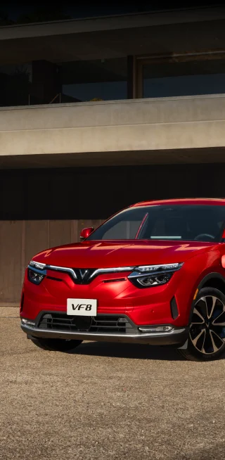 A red VF 8, from the new electric car company VinFast, drives down the highway