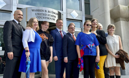 FILE - Two teens challenging New Hampshire's new law banning transgender girls from girls' sports teams pose with their families and attorneys in Concord, N.H., Monday, Aug. 19, 2024, after a judge granted an emergency request to allow one of the girls to play soccer while their lawsuit continues. (AP Photo/Holly Ramer, File)