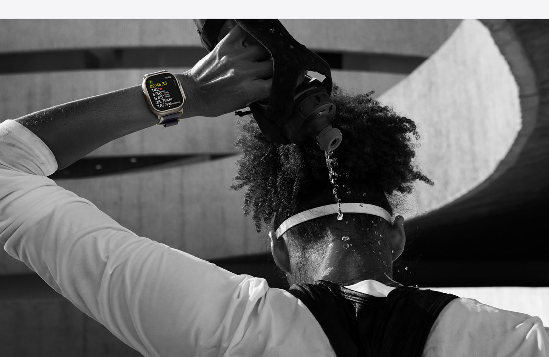 Atleta derramando água na nuca com um Apple Watch Ultra 2 no pulso.