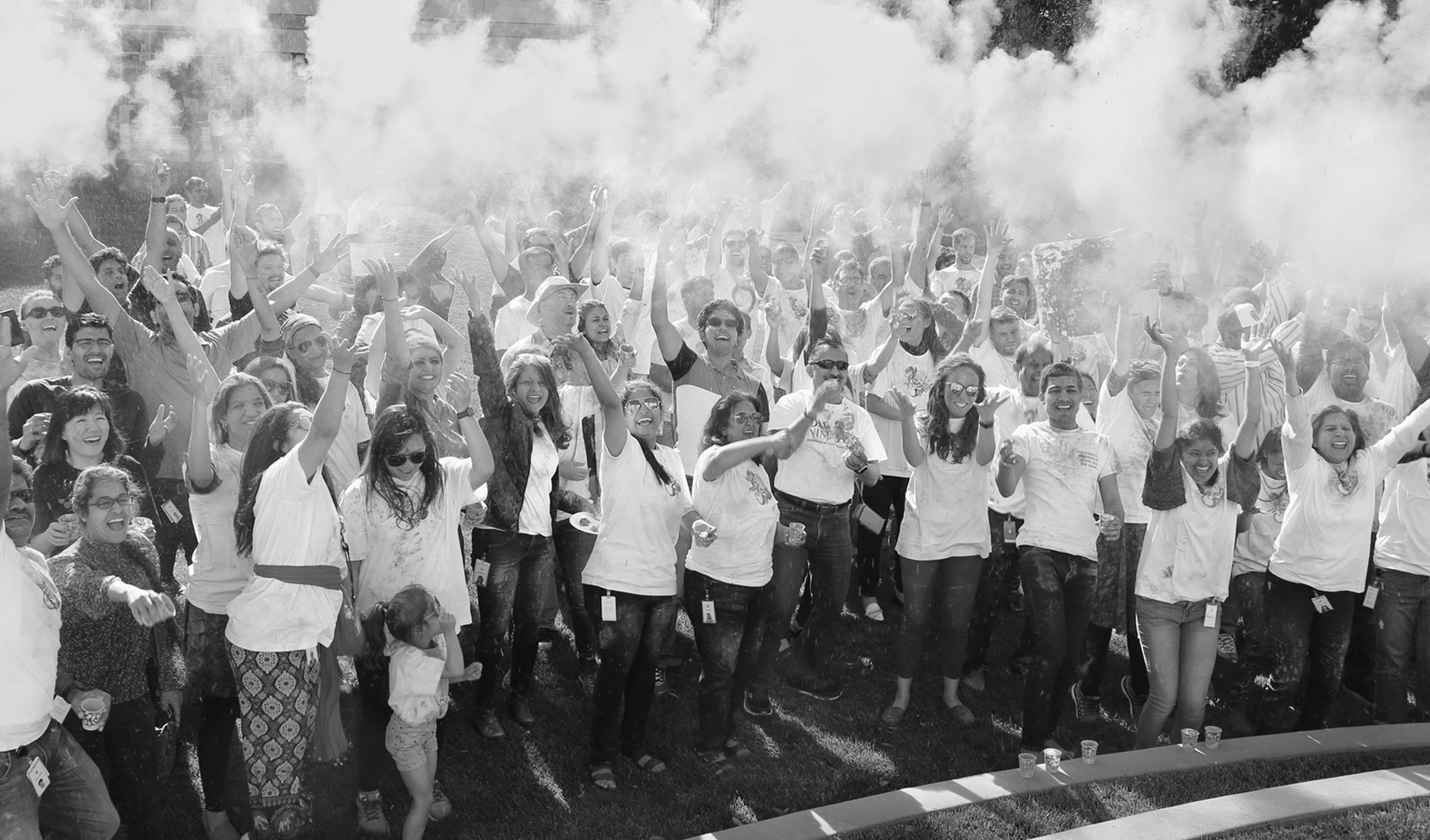 Fotografia de um grande grupo de funcionários a celebrar no exterior de um campus da Apple.