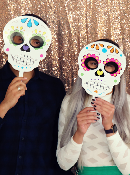 Retrato de duas pessoas a usar máscaras do Día de Muertos.