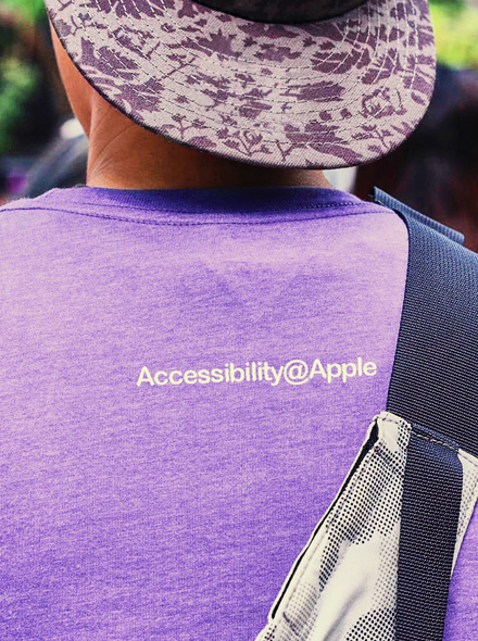 Fotografia de uma pessoa de costas a usar uma t-shirt com a inscrição "Accessibility@Apple".