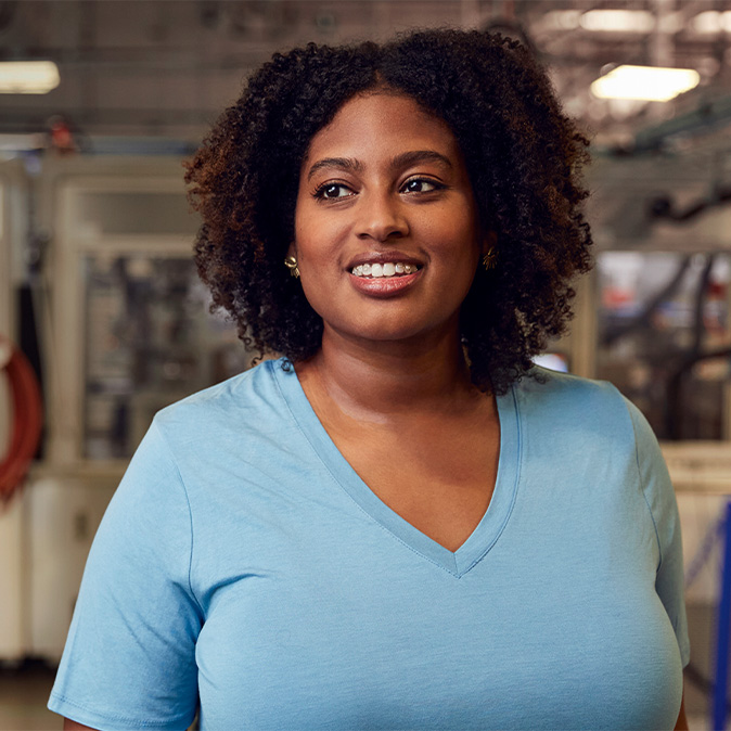 Camara in the Material Recovery Lab, smiling and looking to the side.