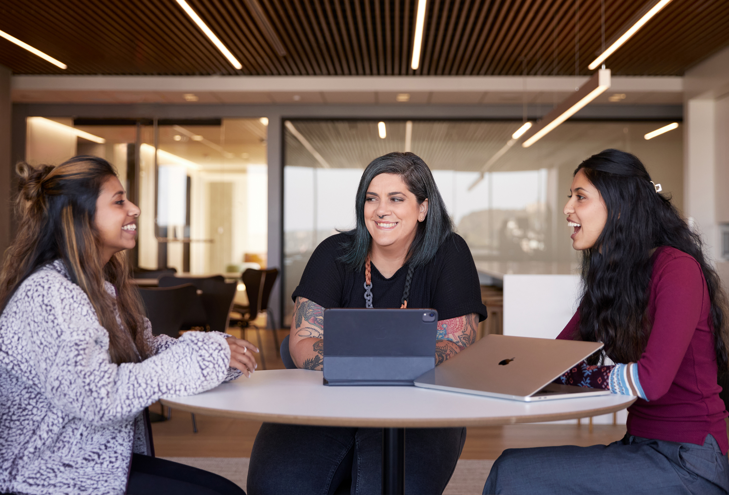 Trois employées Apple discutent, assises.