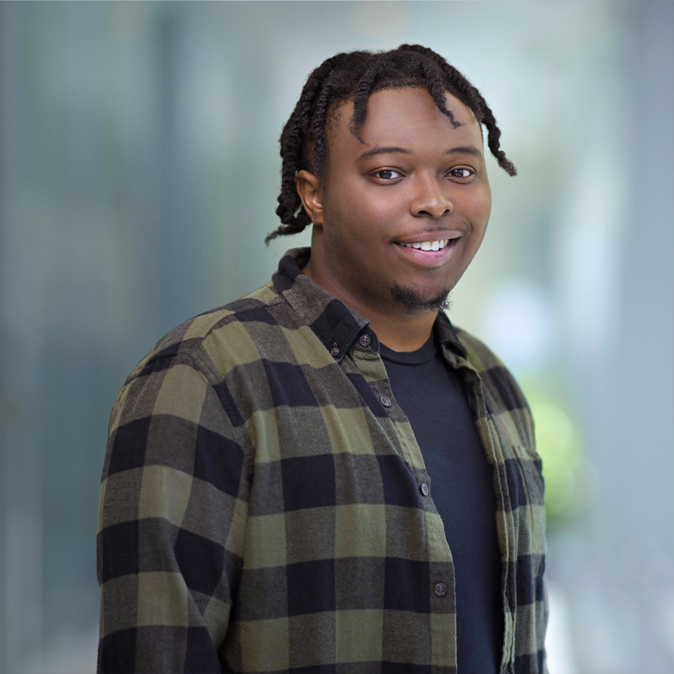 Quincy, standing, smiling into the camera