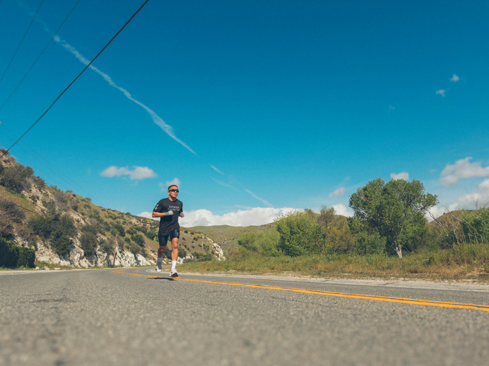 Angelo Antonio running in the middle of a road.