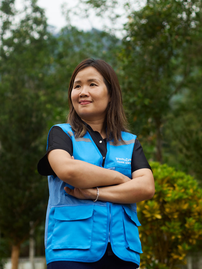 Ett porträtt av Chu Thanh Hoa som står utomhus, iförd en blå Gravity Water-väst.