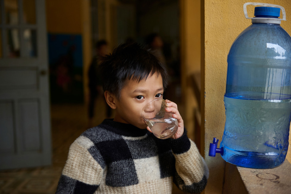 En elev dricker vatten som hämtats från Gravity Waters system på Vay Nua, en grundskola för etniska minoriteter.