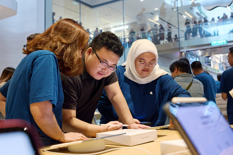 Integrantes de Apple The Exchange TRX con un cliente que está usando un Apple Pencil y un iPad.