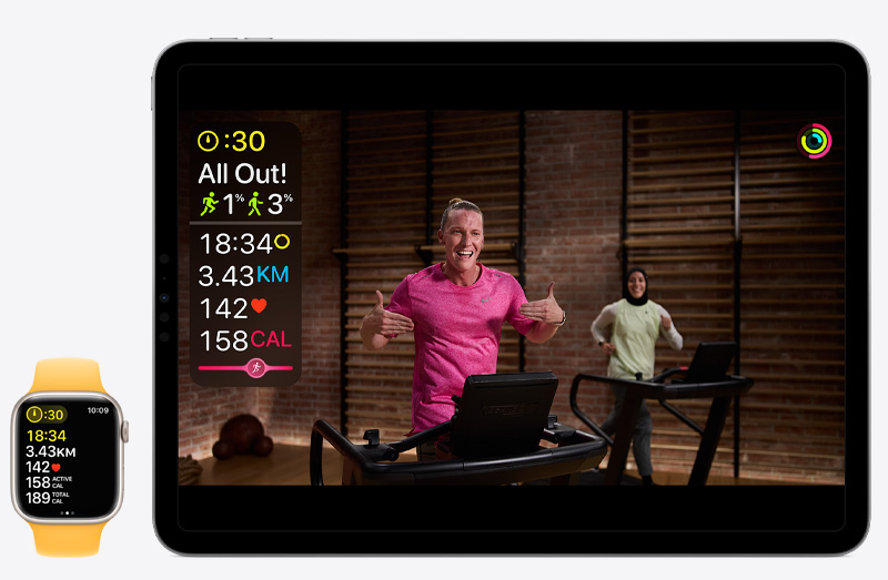 An iPad Pro showing an Apple Fitness  workout next to an Apple Watch Series 9 tracking that same Apple Fitness  workout.