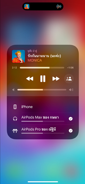 AirPods Pro ในเคสชาร์จที่วางอยู่ข้าง iPhone ในขณะที่ iPhone เชื่อมต่ออยู่กับ AirPods สองคู่โดยที่แต่ละคู่มีแถบควบคุมระดับเสียงของตัวเอง