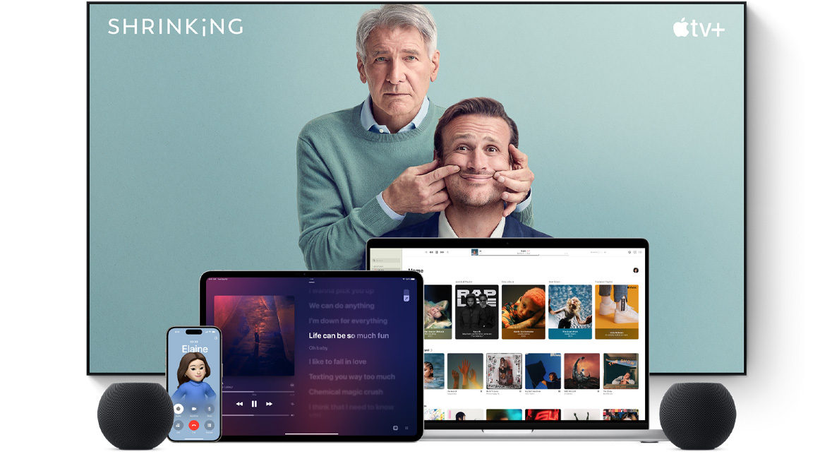 ทีวีจอแบนขนาดใหญ่แสดงตัวละครชายสองคนจากซีรีส์เรื่อง Shrinking ของ Apple TV  โดยมี MacBook Pro, iPad, iPhone และ HomePod mini สีมิดไนท์วางอยู่ด้านหน้า