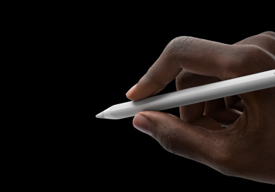 De hand van een gebruiker houdt Apple Pencil Pro vast om ermee te schrijven. De punt wijst naar een interface met het nieuwe toolpalet.