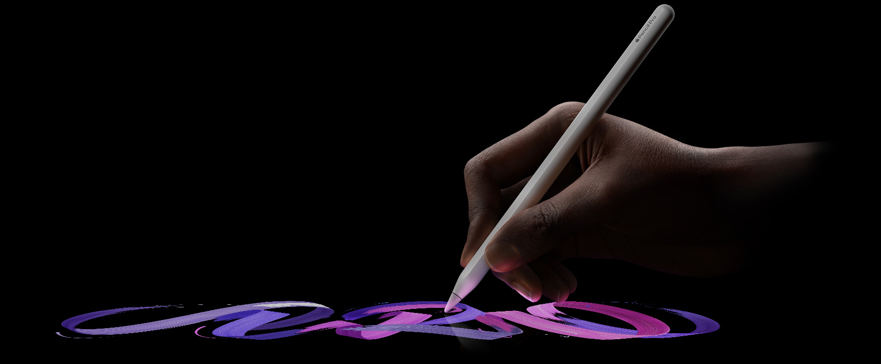 ผู้ใช้ถือ Apple Pencil Pro ในมือ แล้วลากเป็นลายเส้นของแปรงสีสันสดใส