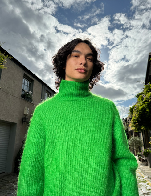 O poză făcută cu iPhone 15 Pro prezentând o persoană cu un pulover viu colorat și o nuanță naturală a pielii