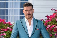 Jax Taylor wearing a blue suit on a grass lawn