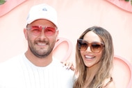 Scheana Shay and Brock Davies posing in front of a step and repeat.