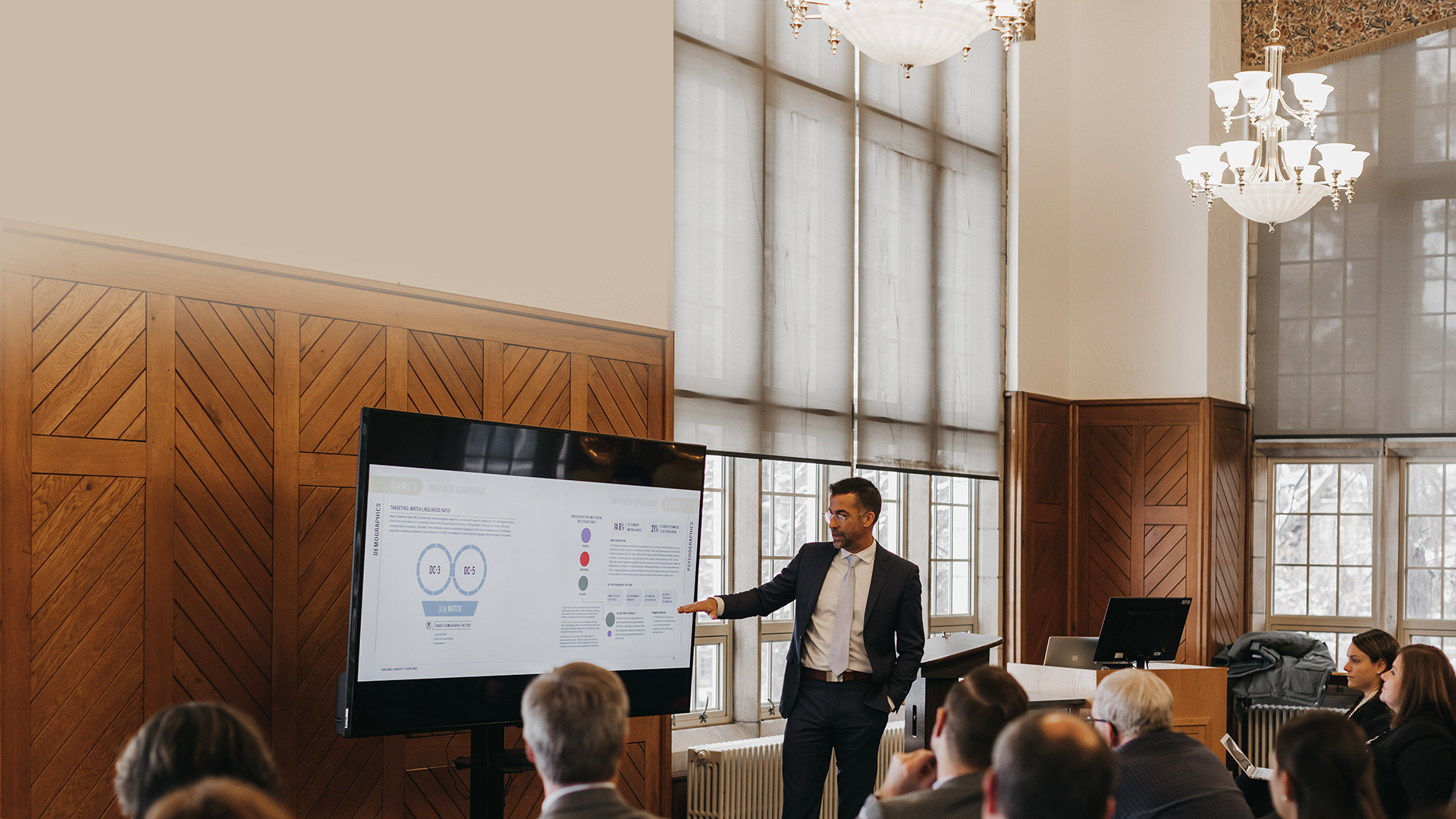 Man in a suit giving a presentation among professionals