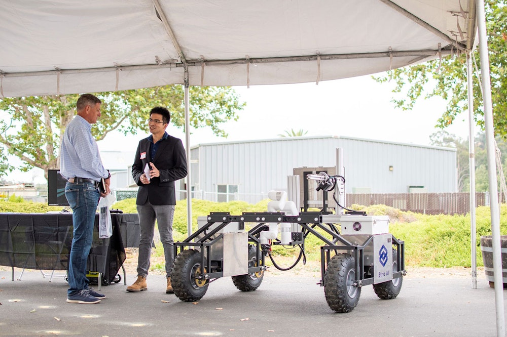 Employees talking in front of a Strio.AI robot