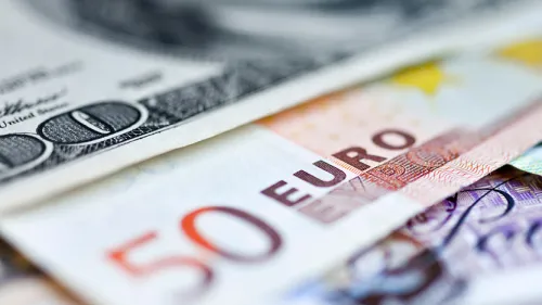 Banknotes from various countries fanned out on a table with blur around the edges of the frame.