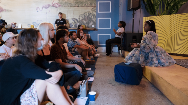 people sitting watching woman on stage