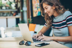 Woman sits at her laptop.