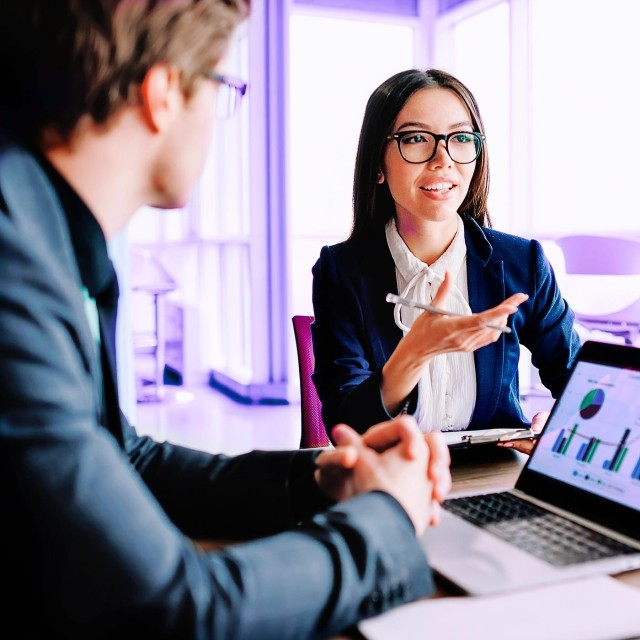 Image of woman explaining to man in an office