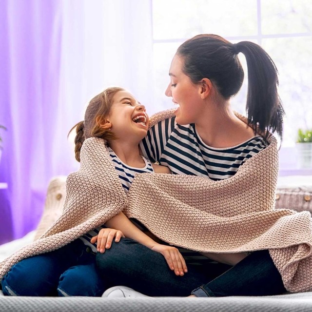 Image of mother and daughter bonding and laughing